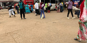 Des voyageurs patientent avec leurs bagages devant une agence de transport à Mvan, Yaoundé