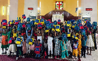 Des enfants tiennent les kits scolaires reçus lors d’une distribution solidaire à Douala