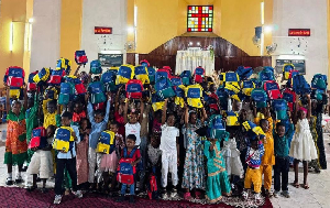 Des enfants tiennent les kits scolaires reçus lors d’une distribution solidaire à Douala