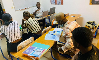 Des joueurs composent des mots en langue Douala sur le plateau du jeu Elomban.